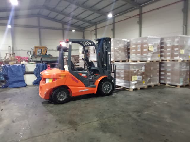 Empilhadeira movimentando paletes dentro de galpão
