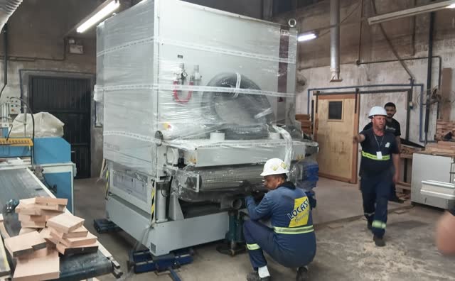 Equipe da Locast movimentando máquina industrial dentro de fábrica