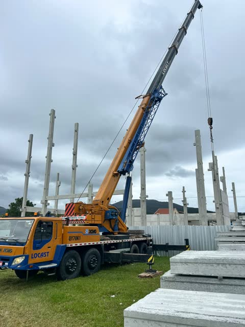 Guindaste telescópico montando pilares pré-moldados de concreto