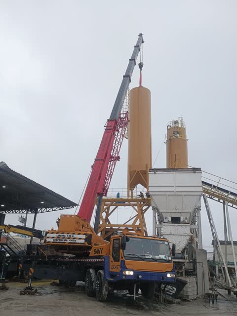Guindaste telescópico içando um silo em usina de concreto