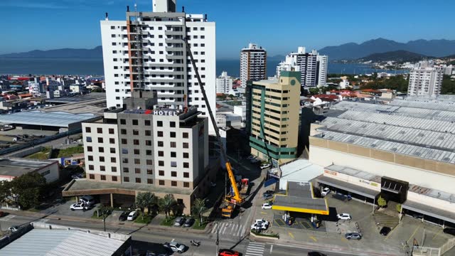 Vista aérea de guindaste telescópico trabalhando entre prédios da cidade