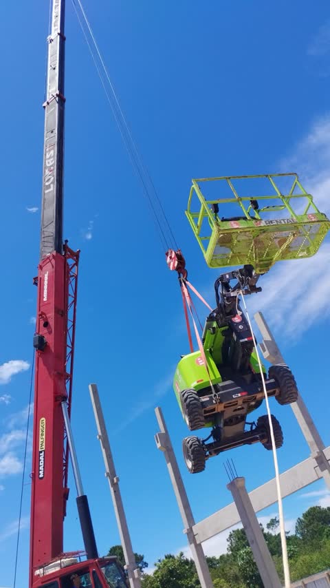 Guindaste telescópico içando uma plataforma elevatória