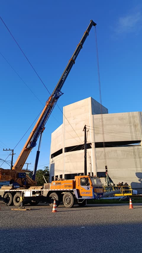 Guindaste telescópico ao lado de um edifício de concreto